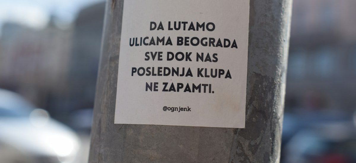 a sticker on a pole on a city street